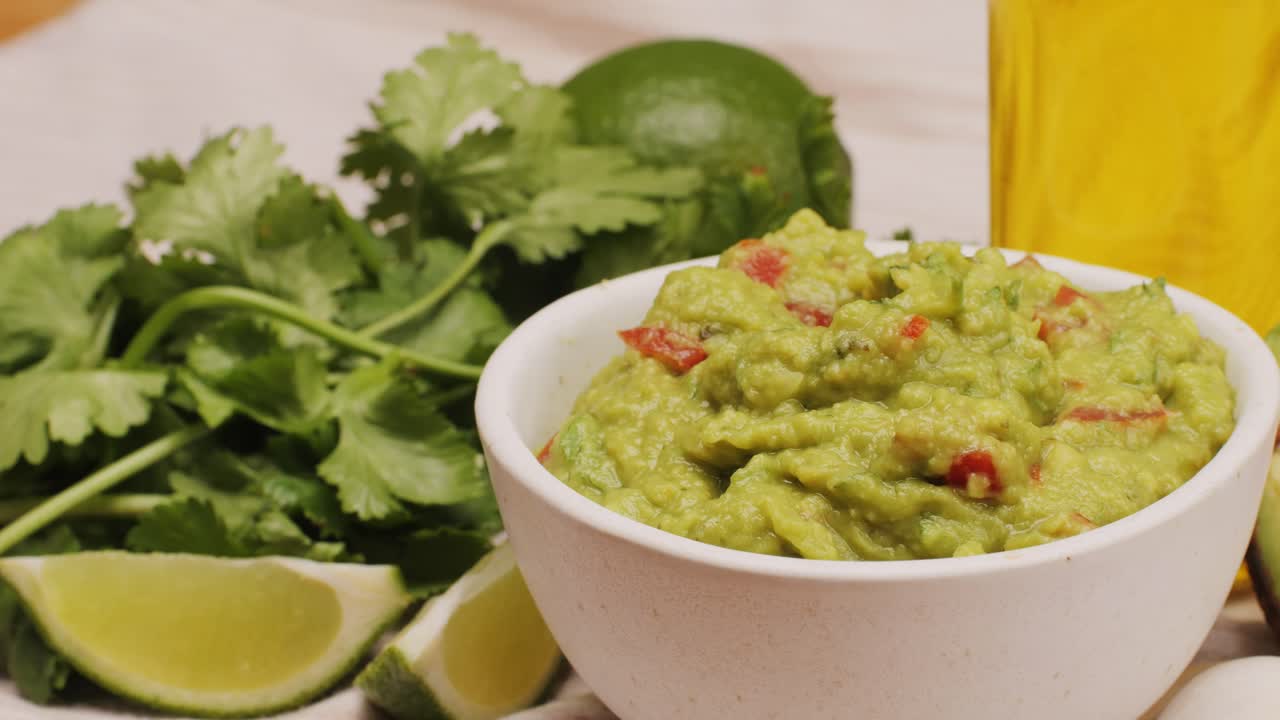 Guacamole in a bowl with ingredients