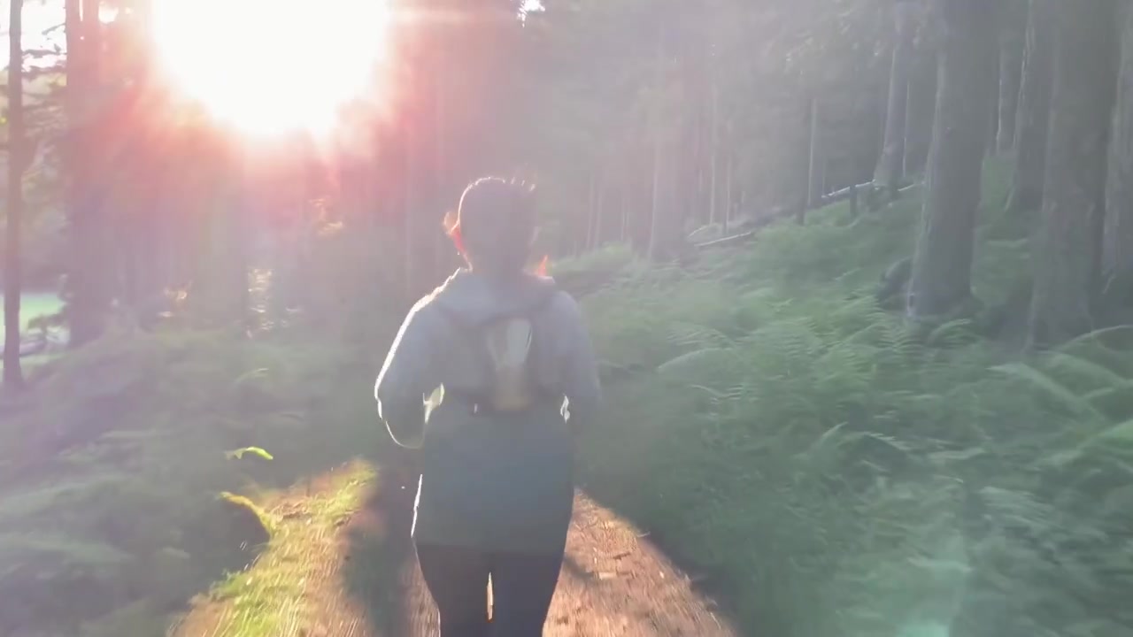 Woman Running on Forest Trail at Sunset