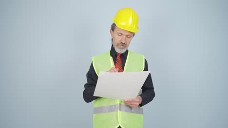 el ingeniero examina el proyecto en sus manos.
