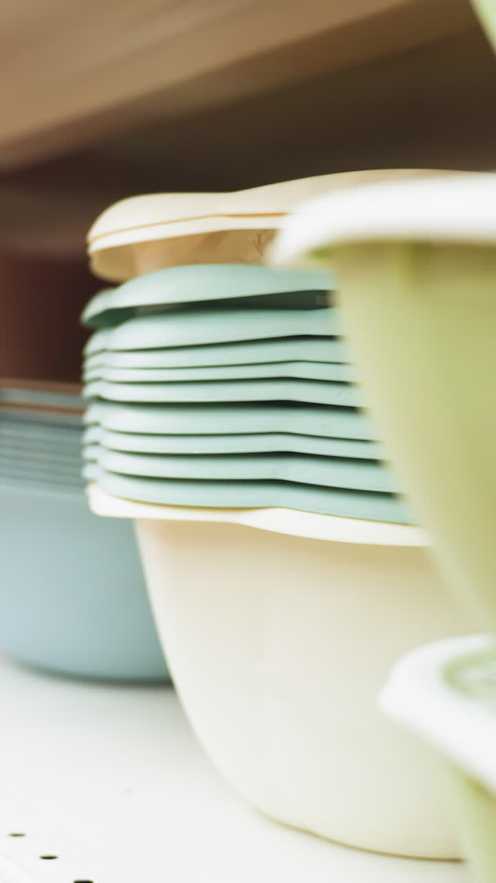 vista de una exhibición cuidadosamente dispuesta de cuencos de varios tamaños y colores en los estantes de las tiendas. capturado con una cámara de mano, este video destaca la organización y la variedad de utensilios de cocina
