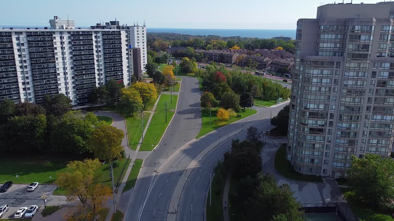 해안가 근처의 아름다운 도시 지역에서 아파트 건물, 도로, 공원, 나무 및 버스 운전
