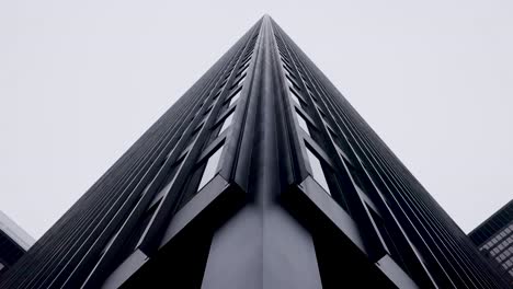 mirando hacia la alta y oscura torre de oficinas monolítica de gran altura en el distrito financiero del centro de toronto