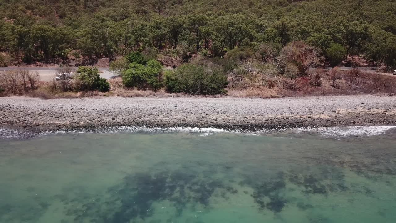 беспилотный летательный аппарат движется боком над тропическим голубым пляжем