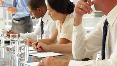 business people taking notes at presentation