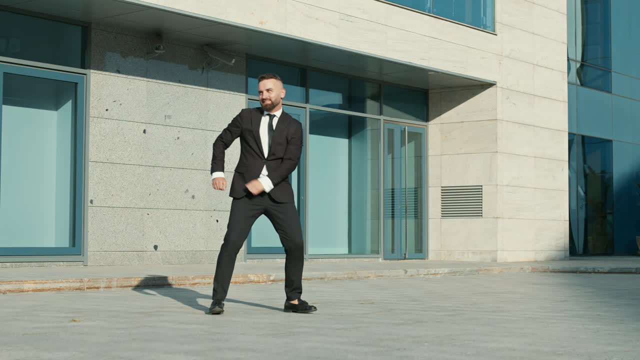 hombre de negocios bailando fuera del edificio de oficinas