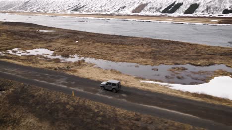 conducción de automóviles grises en islandia junto a un río