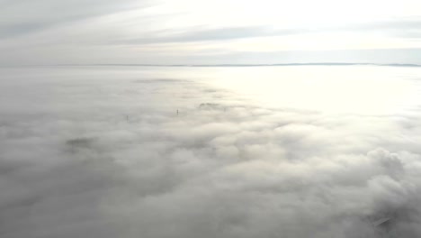 heavy fog over the city. the camera moves uphill and opens a panorama of the fog that lies over the city.