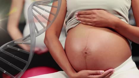 dna strand rotating over happy pregnant biracial woman holding belly in prenatal class