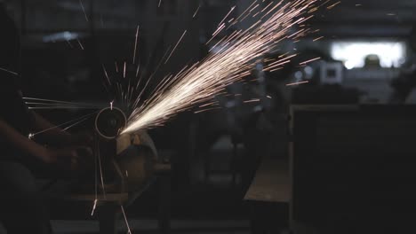 man hard worked and sawing steel. worker using cutter circular metal has lighting spark. concept of engineering, workshop, industry, manufacture and business.