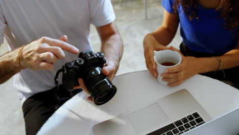 Male-photographer-and-female-model-discussing-over-laptop-4k