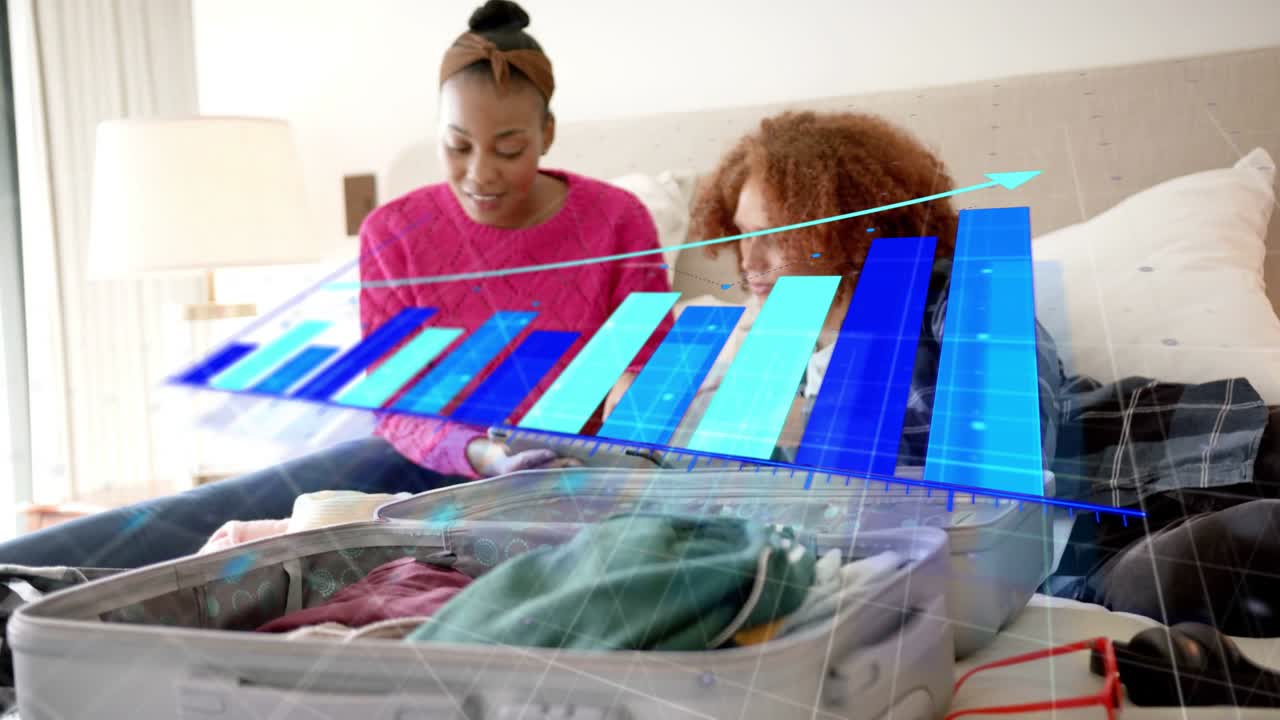 Couple on bed tapping device and causing 3D bar chart above open suitcase packing for travel