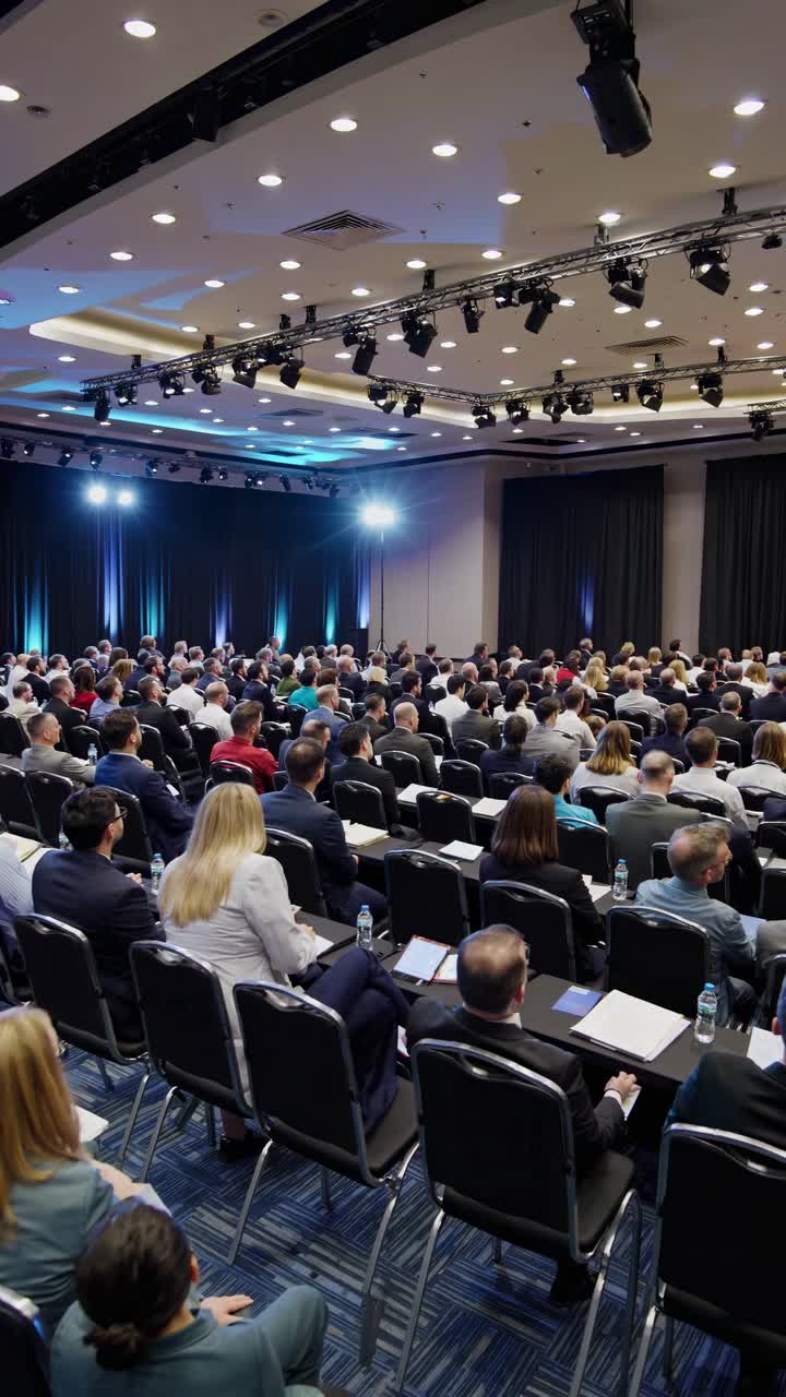 Audience listening to a speaker at a business conference, with entrepreneurs and businessmen engaging in professional development and networking in a corporate setting