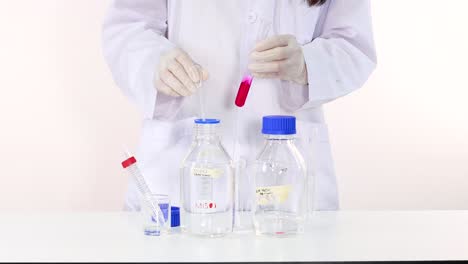 experimento científico con vasos, tubos y líquido