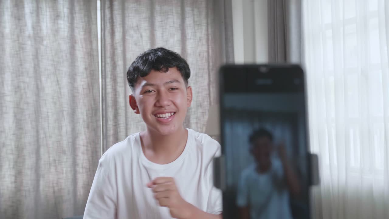 Asian Boy Dancing While Shooting Video Content For Social Networks With A Smartphone Camera