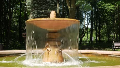 a small fountain with water in the summer park - a place of rest from the heat