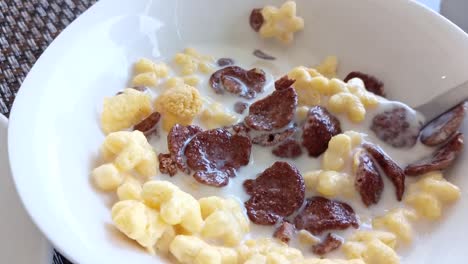 Cámara-Lenta-De-Revolver-Cereal-En-Un-Tazón-De-Leche-Para-El-Desayuno