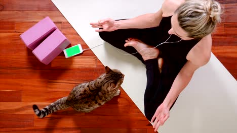 young woman doing yoga with smart phone