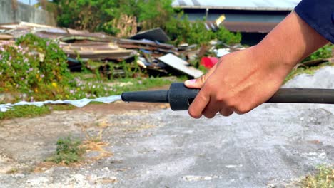 caucasian man holds hose of fire extinguisher on sprays to extinguish fire