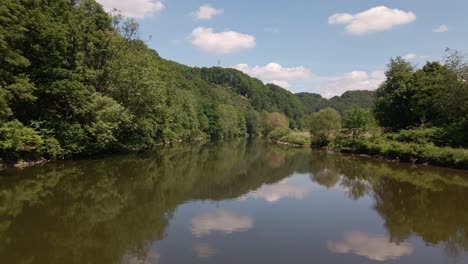 Niedriger-Drohnenflug-über-Einem-Breiten-Braunen-Fluss,-Der-Den-Wunderschönen-Himmel-Darüber-Widerspiegelt