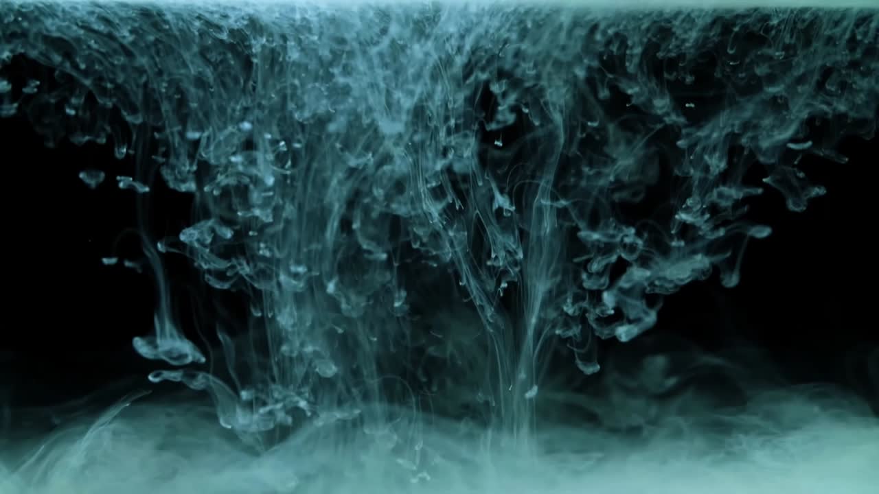 White paint drops from above mixing in water