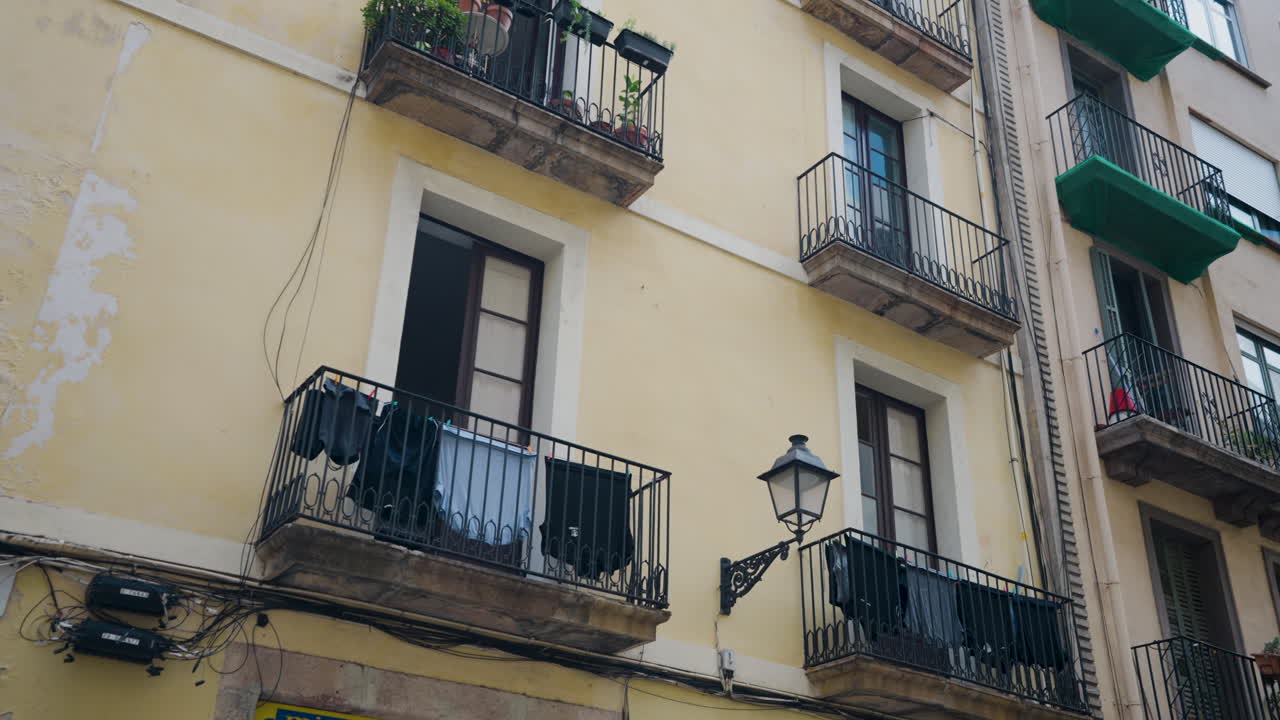 Panni stesi ad asciugare su un balcone di un edificio giallo a Barcellona, Spagna