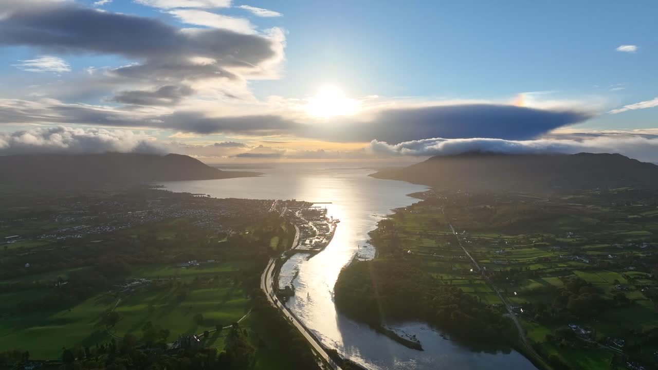 Flagstaff, County Down, Northern Ireland, November 2022. Drone pulls backwards north west over the Newry river during the dawn sunrise with Warrenpoint and Carlingford Lough in the distance.