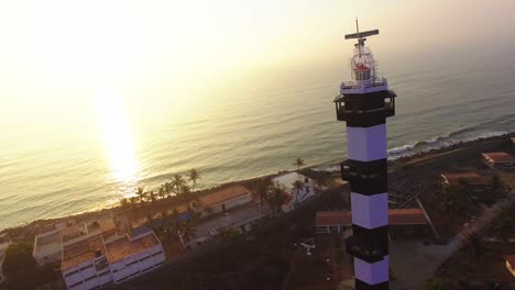 panorámica alrededor de un faro ubicado en pondichery, india, con la playa temprano en la mañana al fondo