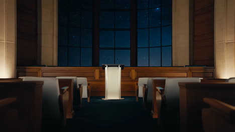an empty auditorium with a podium and a night sky view