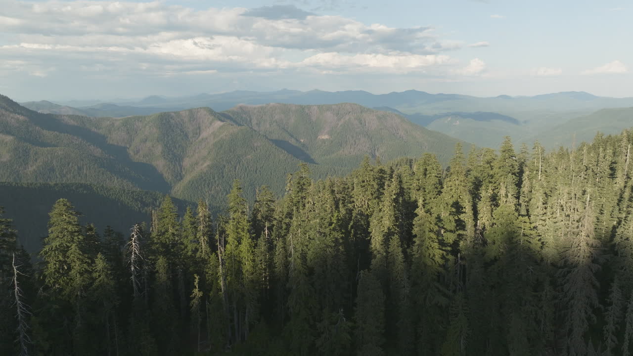 Flying out of shadows over beautiful mountain lake in Gifford Pinchot National Forest, Washington State in Soda Peaks area.