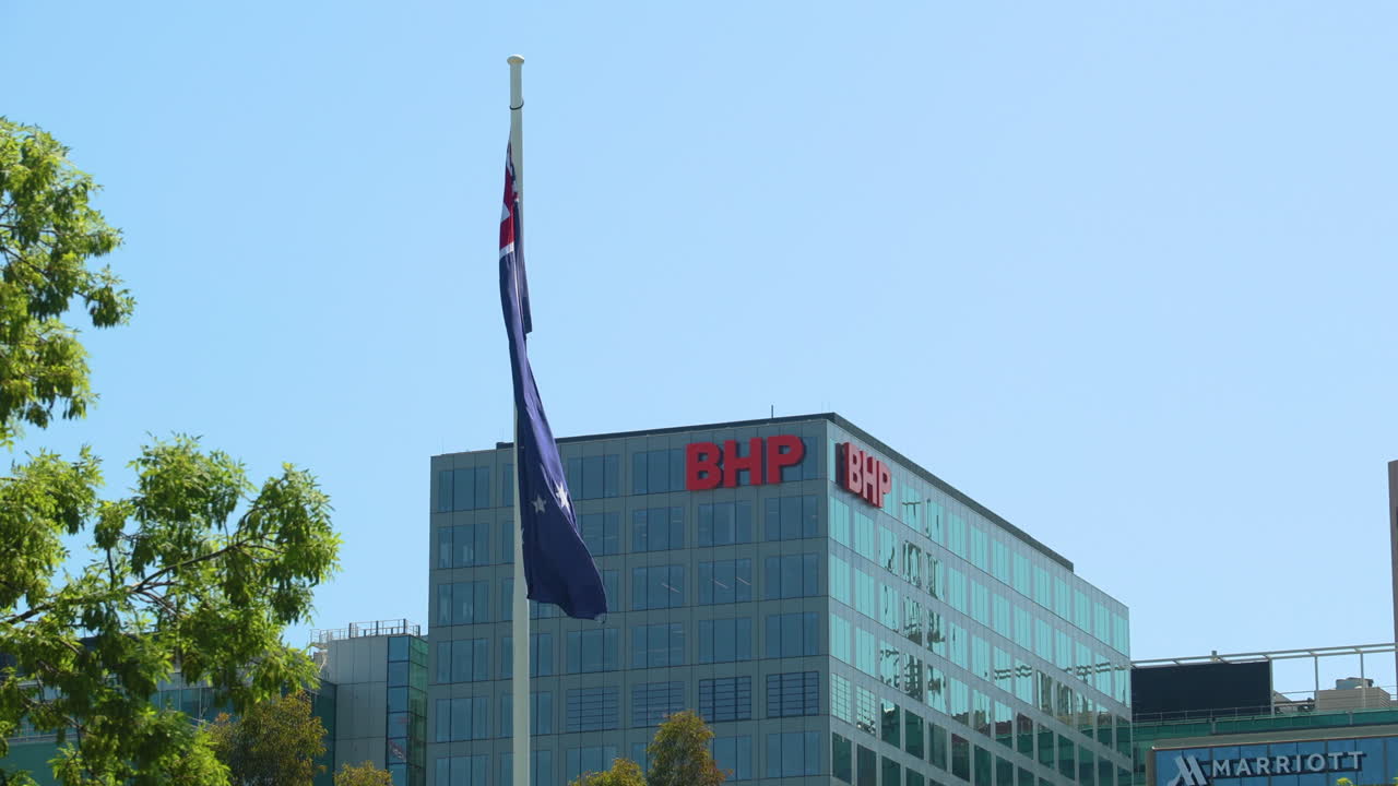 The Australian flag blowing in the wind in front of the BHP building in Adelaide, South Australia. Perfect for projects about mining, corporations, Australia, business, and resources.