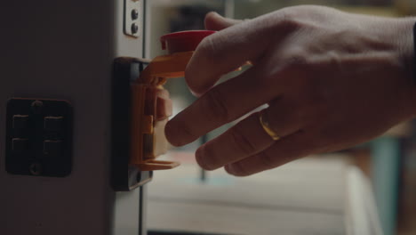 woodworker pushing turn on button on bandsaw machine