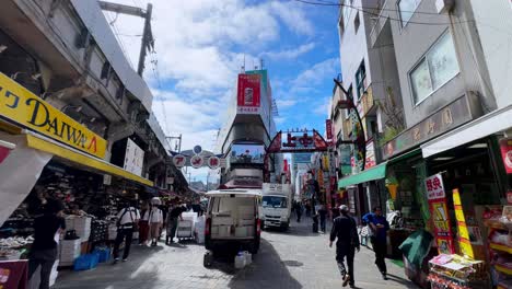 bustling street market in tokyo with colorful signs and shops under a bright blue sky