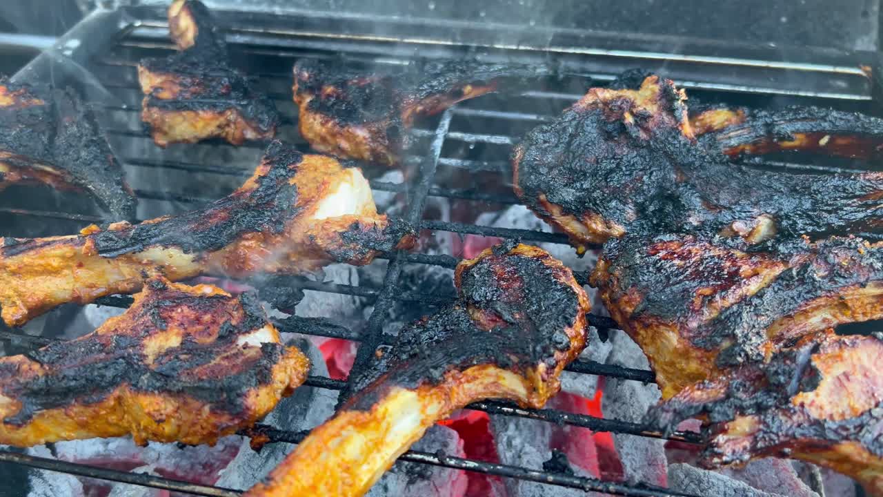 chuletas de cordero cocinadas sobre llamas abiertas en la parrilla
