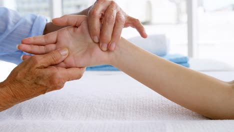 primer plano de la terapeuta masajeando la mano de su paciente