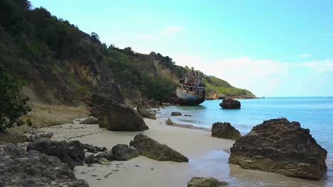 Low-Flying-Slow-Push-in-Aerial-Drone-shot-of-Shipwreck-in-Anguilla-with-clear-blue-skies-on-the-Caribbean-shoreline