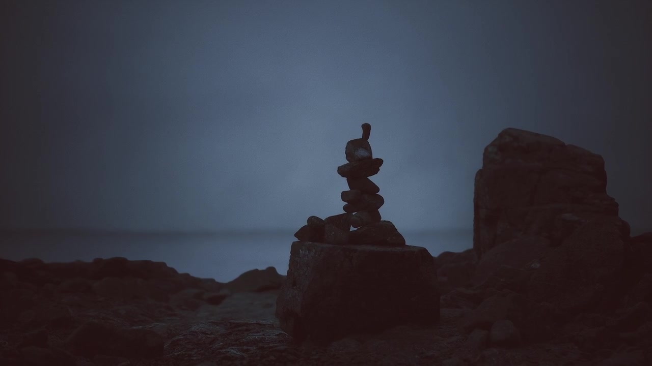Vista sul mare con una struttura rocciosa solitaria sotto il cielo serale.