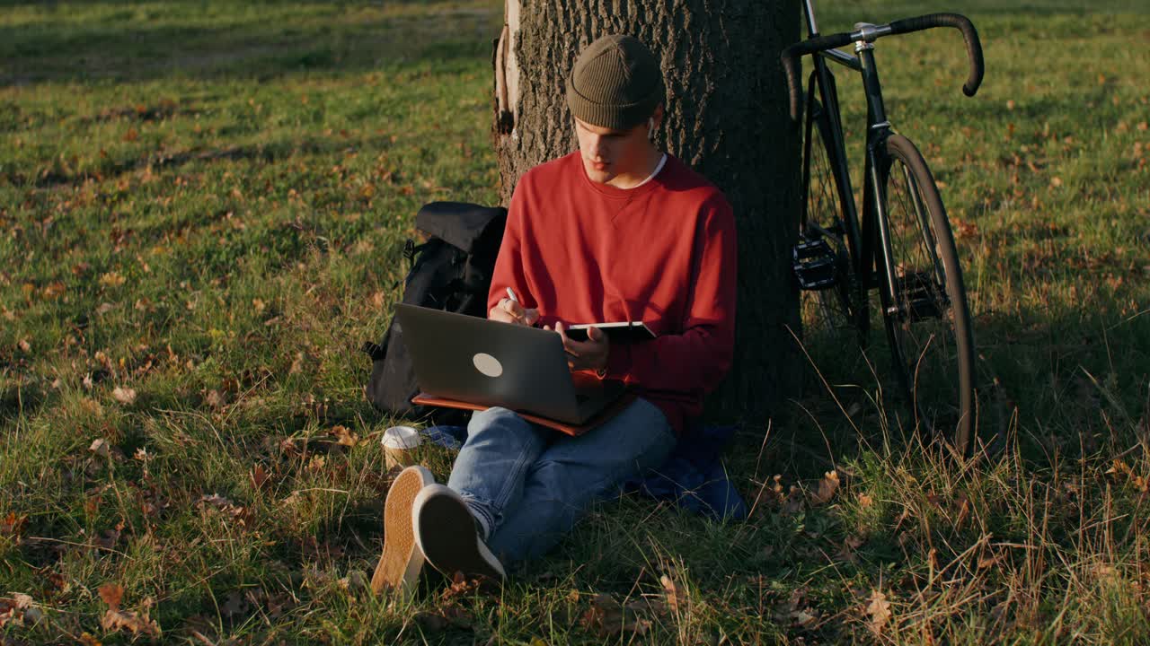молодой человек, работающий на открытом воздухе в парке