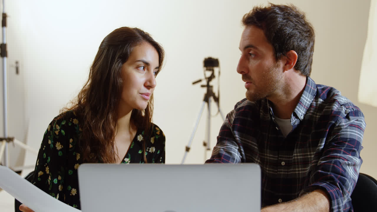 fotógrafos discutiendo sobre la computadora portátil en el escritorio 4k