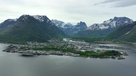 andalsnes norway aerial view - city in stunning nordic surroundings with green landscape and snow capped mountains