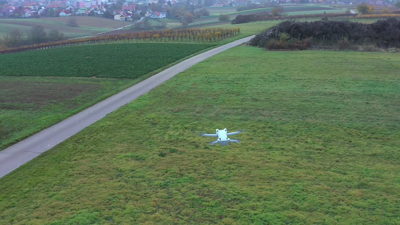 화창한 날에 아름다운 잔디밭 위에 떠 있는 흰색 쿼드콥터 드론