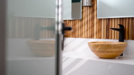 slider shot showing the interior of a luxurious bathroom with wood, mirrors and marble details