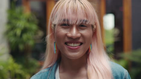 smiling transgender person with pink hair