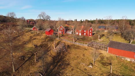 Aéreo---Casas-De-Madera-Roja,-Asens-Por-Reserva-Cultural,-Suecia,-Plano-Amplio-Hacia-Adelante