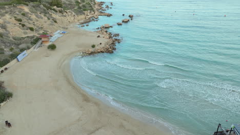 Friedlicher-Weißer-Sandstrand-Auf-Zypern-Bei-Sonnenuntergang,-Kleine-Wellen-Des-Mittelmeers-Rollen-In-Richtung-Inselküste---Luftaufnahme