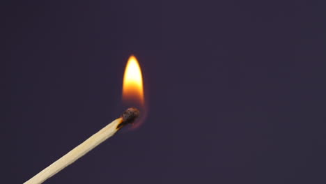 fósforos encendidos a mano primer plano macro capturado desde el lado izquierdo y fuego lateral sobre fondo negro en cámara lenta a 120 fps