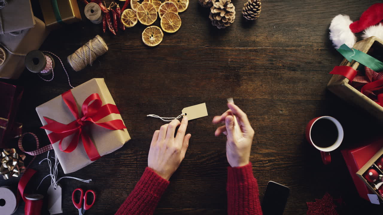 vista superior manos escribiendo nombre en etiqueta de regalo regalos de navidad desde arriba - dragón épico rojo