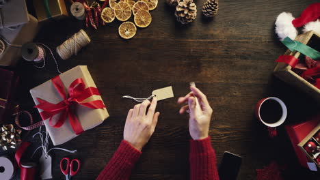 vista superior manos escribiendo nombre en etiqueta de regalo regalos de navidad desde arriba - dragón épico rojo