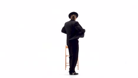 man in suit and hat posing and jumping on white background