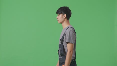 man in coveralls walking on green screen