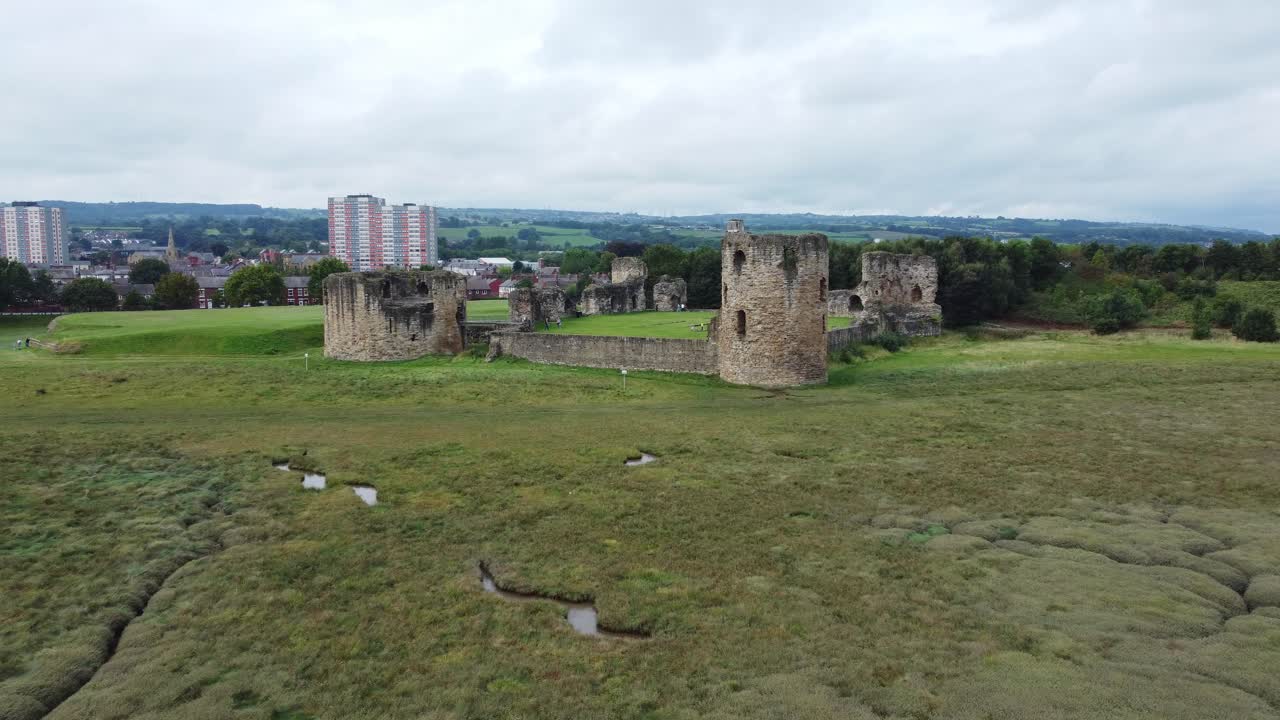 castillo de pedernal galés fortaleza militar costera medieval ruina vista aérea baja empujar desde la distancia
